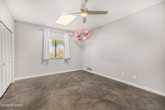 9840 N Desert Sky Rd, Tucson, AZ 85737 - unfurnished bedroom featuring concrete floors, a closet, baseboards, a skylight, and a ceiling fan