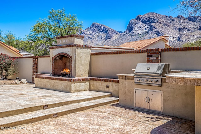 9840 N Desert Sky Rd, Tucson, AZ 85737 - view of patio with a warm lit fireplace and a mountain view
