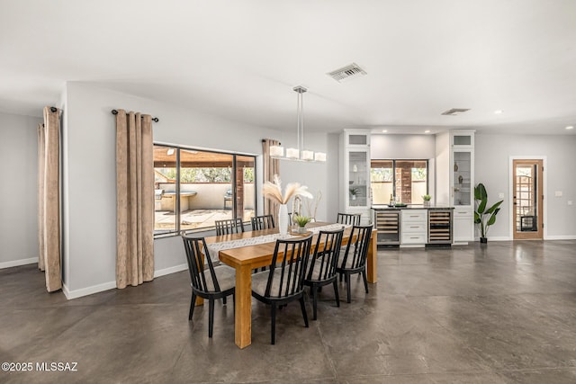 9840 N Desert Sky Rd, Tucson, AZ 85737 - dining room featuring beverage cooler, concrete floors, baseboards, plenty of natural light, and recessed lighting