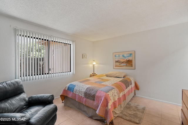 2819 W Jennie Ln, Tucson, AZ 85713 - bedroom with light tile patterned floors, a textured ceiling, and baseboards