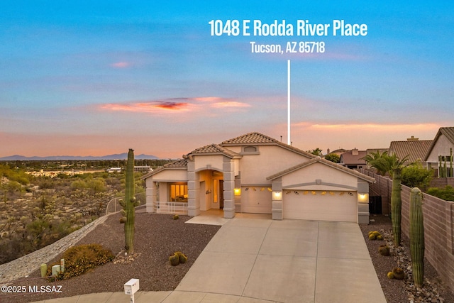 1048 E Rodda River Pl, Tucson, AZ 85718 - mediterranean / spanish home featuring a tile roof, an attached garage, stucco siding, driveway, and a mountain view