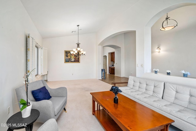 1048 E Rodda River Pl, Tucson, AZ 85718 - living room with arched walkways, lofted ceiling, a chandelier, and light colored carpet