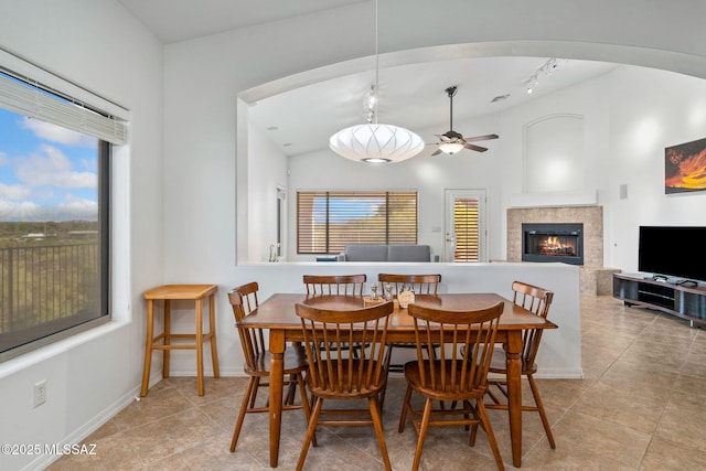 1048 E Rodda River Pl, Tucson, AZ 85718 - dining space featuring plenty of natural light, a tile fireplace, light tile patterned floors, and a ceiling fan