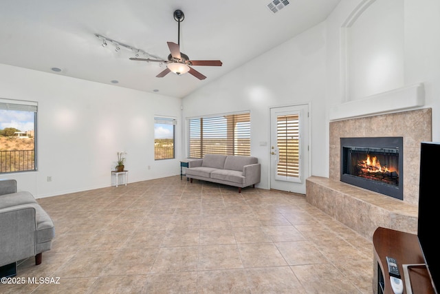 1048 E Rodda River Pl, Tucson, AZ 85718 - living room with a ceiling fan, a premium fireplace, light tile patterned floors, high vaulted ceiling, and track lighting