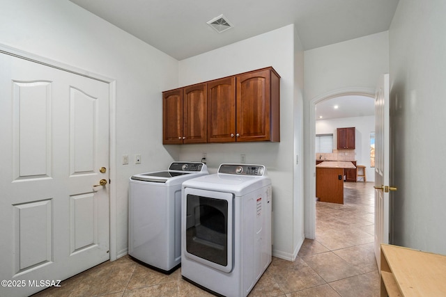 1048 E Rodda River Pl, Tucson, AZ 85718 - laundry area featuring independent washer and dryer, cabinet space, and light tile patterned floors