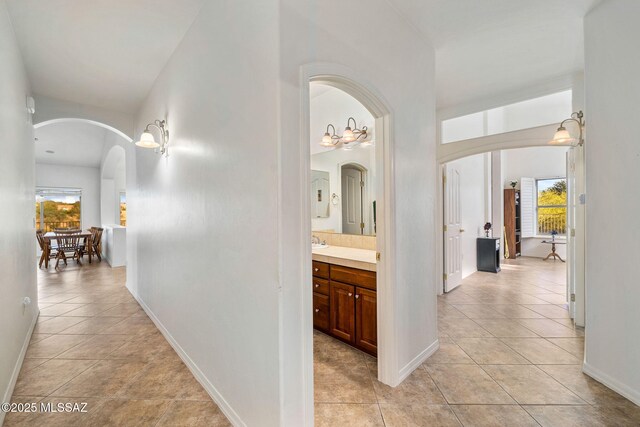 1048 E Rodda River Pl, Tucson, AZ 85718 - hall featuring arched walkways, healthy amount of natural light, and light tile patterned floors
