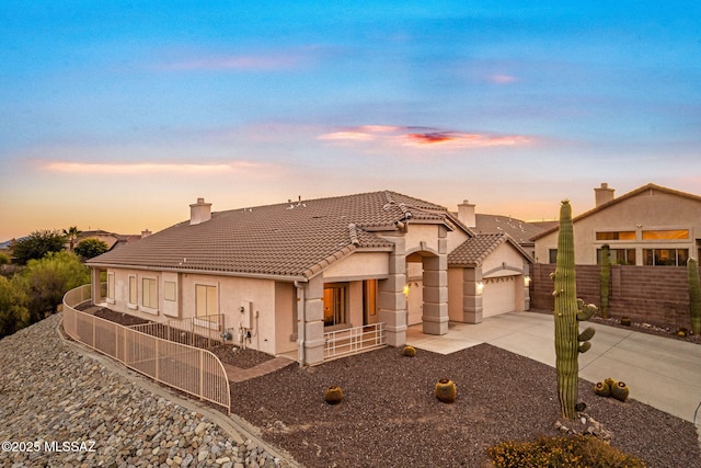 1048 E Rodda River Pl, Tucson, AZ 85718 - view of front of house featuring a tile roof, a chimney, driveway, and stucco siding