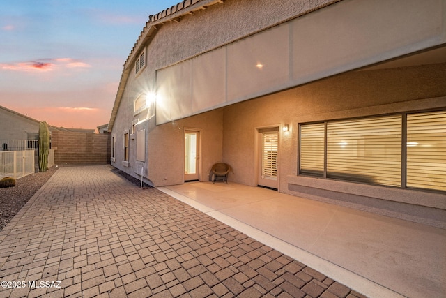 1048 E Rodda River Pl, Tucson, AZ 85718 - property exterior at dusk featuring a patio and stucco siding