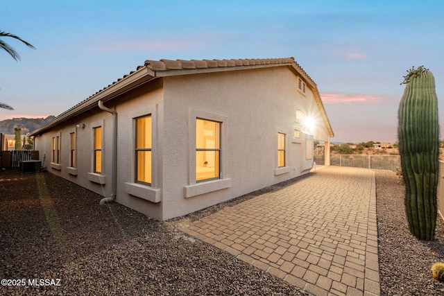 1048 E Rodda River Pl, Tucson, AZ 85718 - property exterior at dusk featuring stucco siding, a patio area, and a tile roof