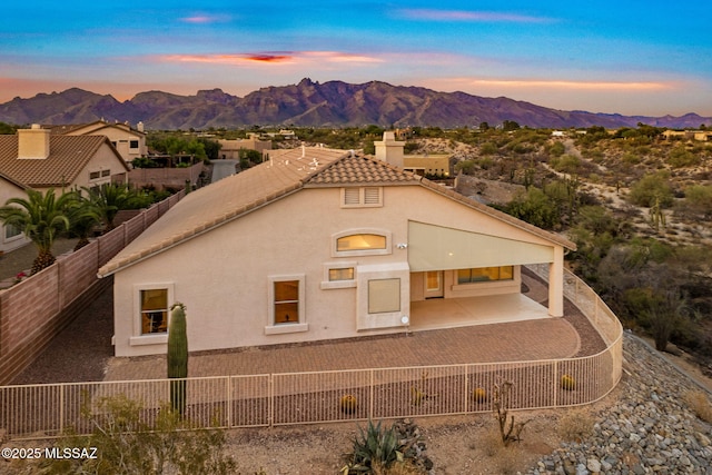 1048 E Rodda River Pl, Tucson, AZ 85718 - back of house featuring a chimney, a mountain view, a fenced backyard, and stucco siding