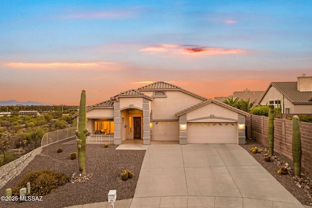 1048 E Rodda River Pl, Tucson, AZ 85718 - mediterranean / spanish home featuring a tiled roof, a garage, stucco siding, and driveway