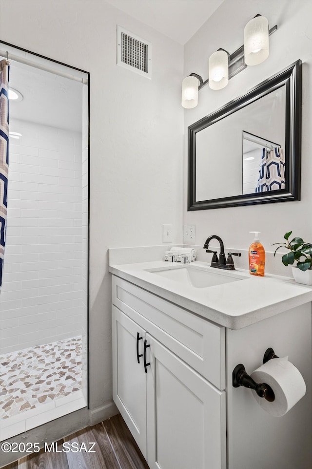 5247 E 6th St, Tucson, AZ 85711 - bathroom featuring a stall shower, vanity, and wood finished floors
