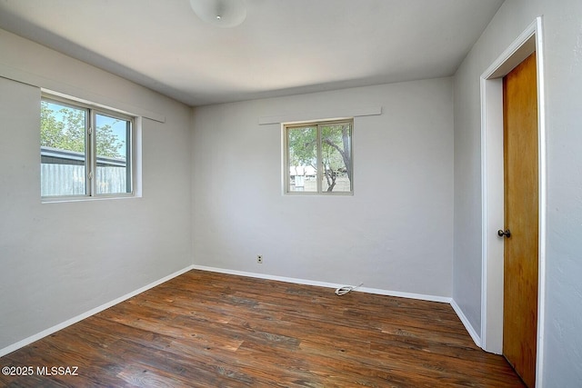 5721 E Scarlett St, Tucson, AZ 85711 - empty room with plenty of natural light, dark wood finished floors, and baseboards