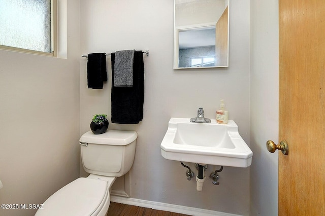 5721 E Scarlett St, Tucson, AZ 85711 - bathroom with toilet, wood finished floors, and baseboards