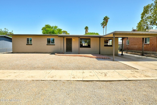 5721 E Scarlett St, Tucson, AZ 85711 - ranch-style home featuring a carport, driveway, and brick siding