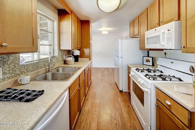 5721 E Scarlett St, Tucson, AZ 85711 - kitchen with white appliances, a sink, light wood-type flooring, tasteful backsplash, and light countertops