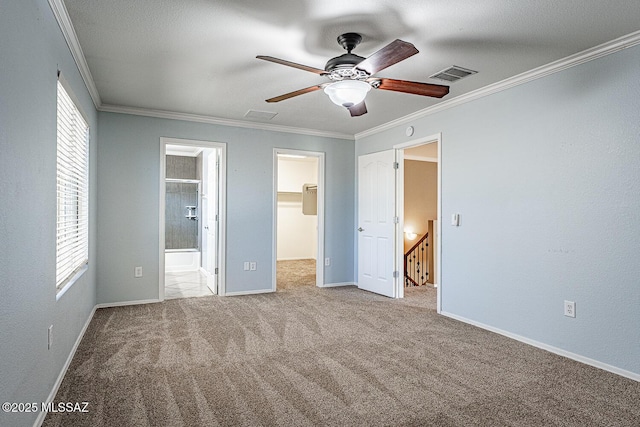 1173 W Calle Vista De Suenos, Sahuarita, AZ 85629 - unfurnished bedroom featuring a walk in closet, ornamental molding, carpet flooring, ensuite bath, and baseboards