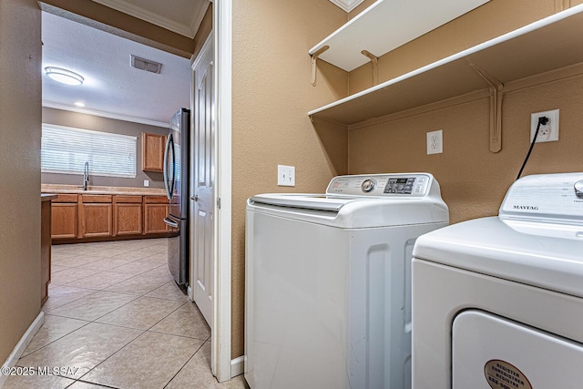 1173 W Calle Vista De Suenos, Sahuarita, AZ 85629 - washroom with crown molding, washer and dryer, and light tile patterned flooring