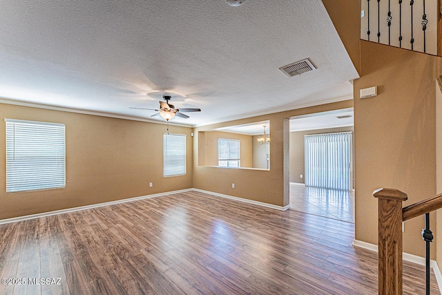 1173 W Calle Vista De Suenos, Sahuarita, AZ 85629 - spare room with a ceiling fan, wood finished floors, a chandelier, baseboards, and a textured ceiling