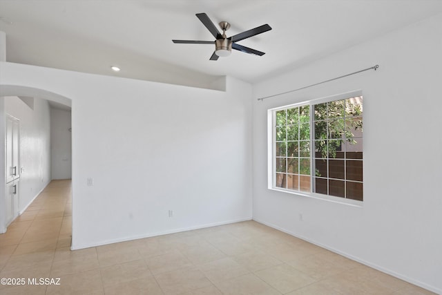 12122 N Sterling Ave, Oro Valley, AZ 85755 - spare room with arched walkways, a ceiling fan, baseboards, and light tile patterned flooring