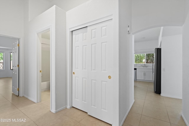 12122 N Sterling Ave, Oro Valley, AZ 85755 - corridor with arched walkways, light tile patterned flooring, a sink, and baseboards