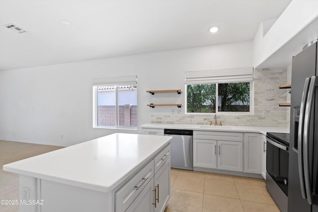 12122 N Sterling Ave, Oro Valley, AZ 85755 - kitchen featuring appliances with stainless steel finishes, open shelves, a sink, decorative backsplash, and plenty of natural light