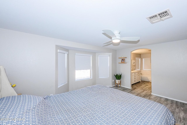 2943 N Gold Creek Pl, Tucson, AZ 85745 - bedroom featuring light wood-style floors, baseboards, arched walkways, and a ceiling fan