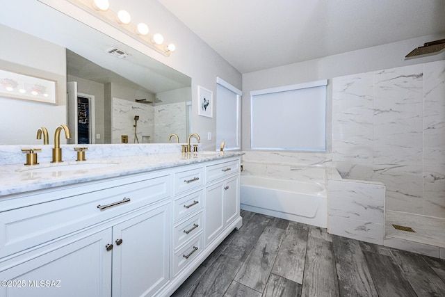 2943 N Gold Creek Pl, Tucson, AZ 85745 - bathroom featuring double vanity, a marble finish shower, a bath, and wood finished floors