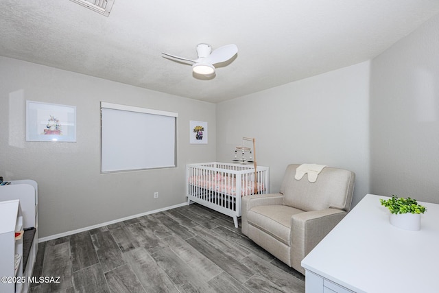 2943 N Gold Creek Pl, Tucson, AZ 85745 - bedroom featuring wood finished floors, baseboards, a nursery area, and a ceiling fan