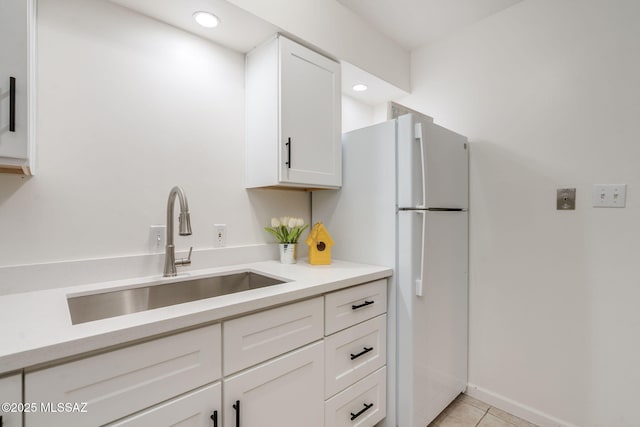 1600 N Wilmot Rd Unit 155, Tucson, AZ 85712 - kitchen featuring a sink, light tile patterned flooring, white cabinets, light countertops, and freestanding refrigerator