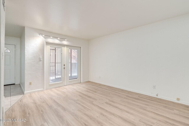 1600 N Wilmot Rd Unit 155, Tucson, AZ 85712 - empty room featuring light wood finished floors, baseboards, and rail lighting
