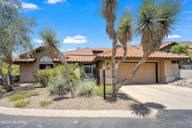 7133 E Grey Fox Ln, Tucson, AZ 85750 - view of front of property featuring an attached garage, stucco siding, a tile roof, and concrete driveway