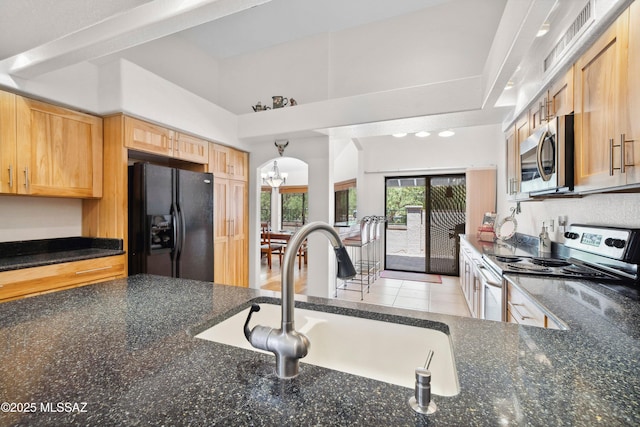 7133 E Grey Fox Ln, Tucson, AZ 85750 - kitchen with appliances with stainless steel finishes, a sink, a chandelier, and dark stone countertops