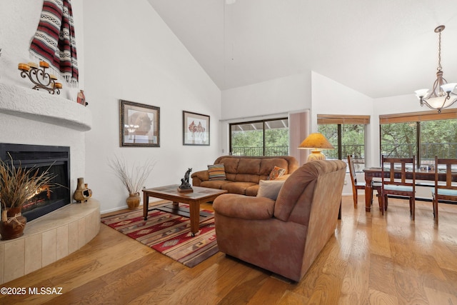 7133 E Grey Fox Ln, Tucson, AZ 85750 - living room featuring high vaulted ceiling, light wood-style floors, a chandelier, healthy amount of natural light, and baseboards