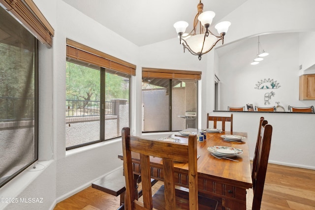 7133 E Grey Fox Ln, Tucson, AZ 85750 - dining area with lofted ceiling, baseboards, a chandelier, and wood finished floors