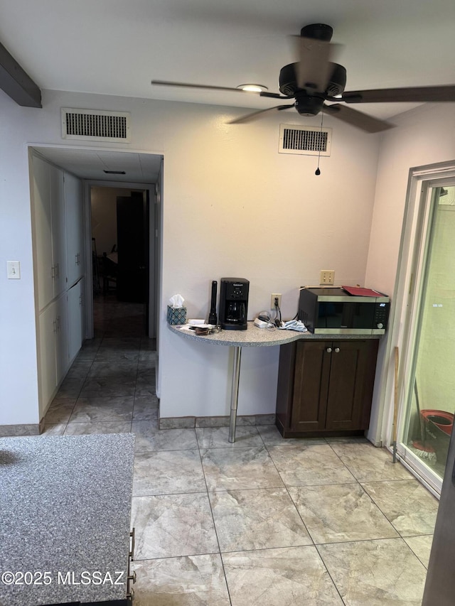 1002 S Kolb Rd Unit 2, Tucson, AZ 85710 - kitchen with a ceiling fan and dark brown cabinetry