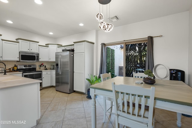 10583 E Forest Falls Ct, Tucson, AZ 85747 - kitchen with stainless steel appliances, a sink, backsplash, light tile patterned floors, and recessed lighting
