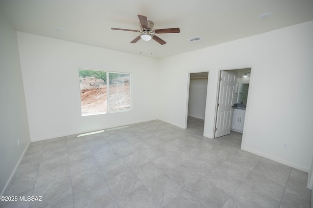 1681 Trampa Ct, Rio Rico, AZ 85648 - unfurnished bedroom with a spacious closet, ceiling fan, light floors, and baseboards