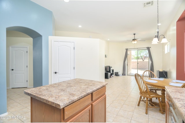 2511 N Avenida Tabica, Green Valley, AZ 85614 - kitchen featuring light tile patterned flooring, a ceiling fan, arched walkways, a center island, and recessed lighting