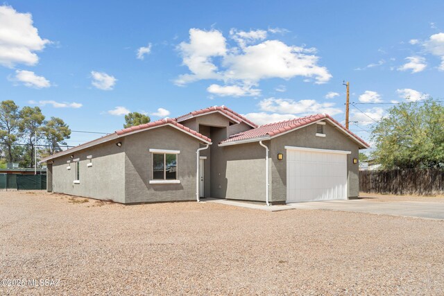 1941 E Greenlee Rd, Tucson, AZ 85719 - mediterranean / spanish-style home featuring driveway, a garage, a tiled roof, and stucco siding