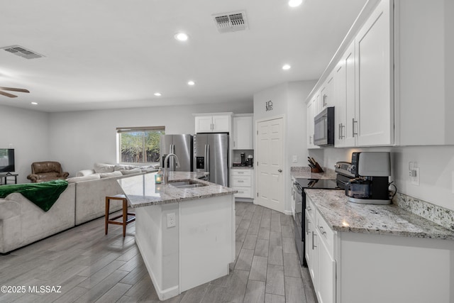 1941 E Greenlee Rd, Tucson, AZ 85719 - kitchen with black electric range oven, stainless steel fridge with ice dispenser, a sink, open floor plan, and white cabinets