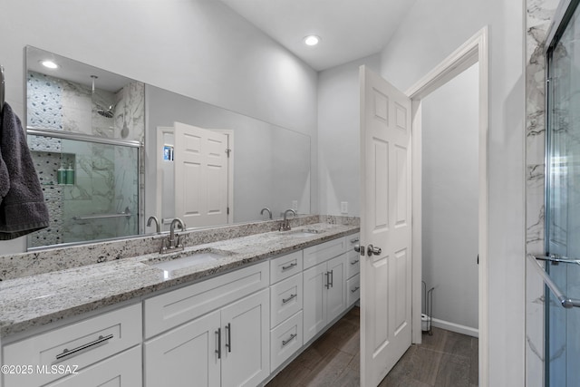 1941 E Greenlee Rd, Tucson, AZ 85719 - bathroom with a marble finish shower, double vanity, wood finished floors, baseboards, and recessed lighting