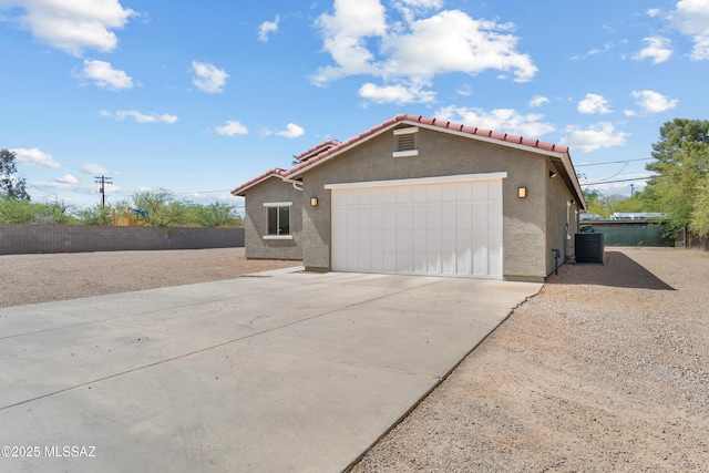1941 E Greenlee Rd, Tucson, AZ 85719 - view of front of property with a tile roof, driveway, stucco siding, an attached garage, and central AC unit