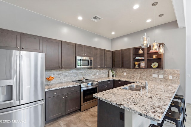1759 E Via Colomba Bianca, Tucson, AZ 85737 - kitchen with stainless steel appliances, a sink, open shelves, dark brown cabinetry, and a peninsula