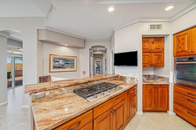 1861 E Crown Ridge Way, Oro Valley, AZ 85755 - kitchen featuring appliances with stainless steel finishes, arched walkways, light stone counters, light tile patterned floors, and recessed lighting