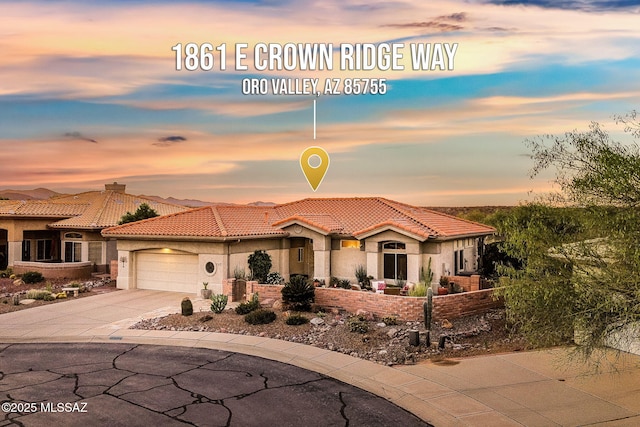 1861 E Crown Ridge Way, Oro Valley, AZ 85755 - mediterranean / spanish-style home featuring a garage, a tiled roof, concrete driveway, and stucco siding