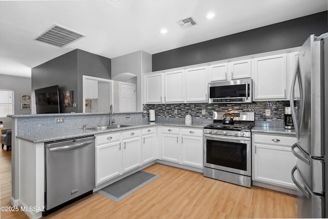 14511 S Camino Tierra Luna, Sahuarita, AZ 85629 - kitchen featuring appliances with stainless steel finishes, a sink, light wood-type flooring, white cabinetry, and tasteful backsplash