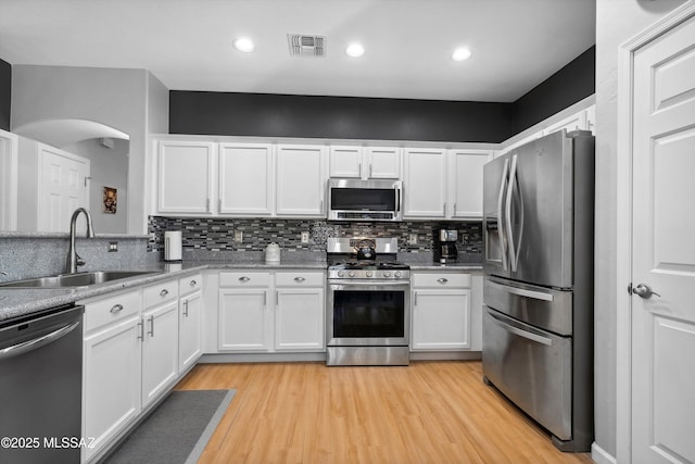 14511 S Camino Tierra Luna, Sahuarita, AZ 85629 - kitchen with appliances with stainless steel finishes, a sink, white cabinets, backsplash, and light wood-style floors