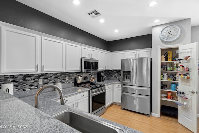 14511 S Camino Tierra Luna, Sahuarita, AZ 85629 - kitchen with appliances with stainless steel finishes, light wood-style flooring, white cabinetry, and recessed lighting