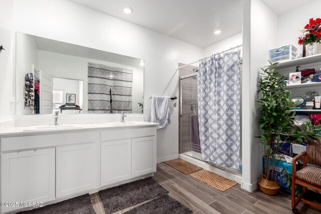 5568 W Summer Vw Dr, Marana, AZ 85658 - bathroom with a stall shower, wood finish floors, double vanity, baseboards, and recessed lighting